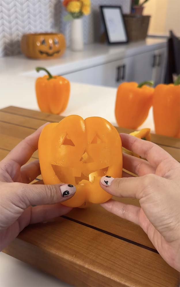 orange bell pepper cut out like a jack o lantern